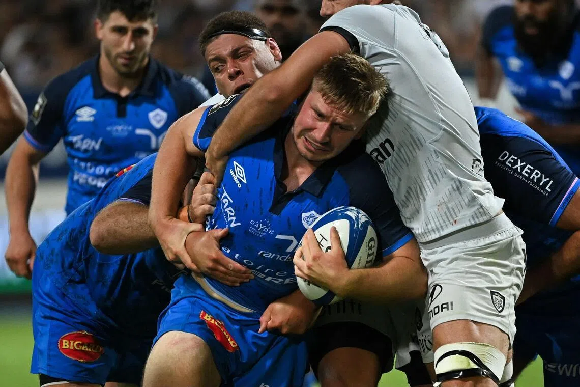 Castres' Australian lock Tom Staniforth (C) is tackled during the French Top 14 rugby union match between Castres Olympique and Rugby Club Toulonnais (Toulon) at Stade Pierre Fabre in Castres, southern France on June 6, 2026. (Photo by Matthieu RONDEL / AFP)