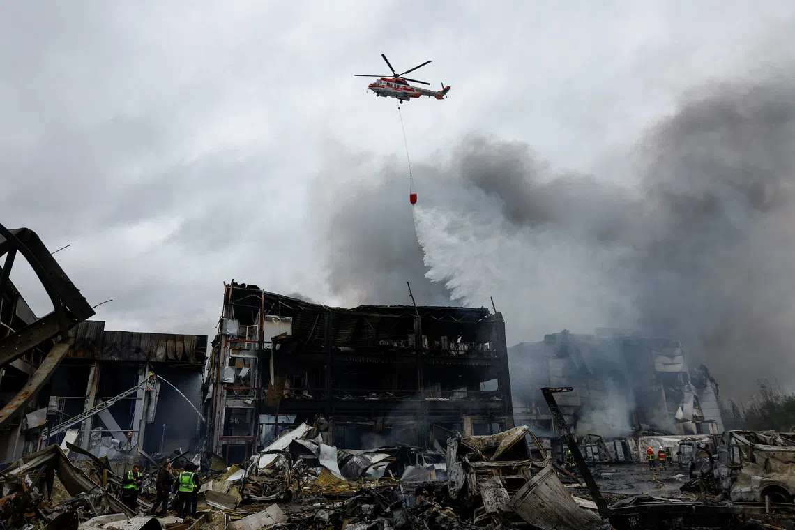 A firefighting helicopter drops water over food warehouses hit by an overnight Russian missile strike, amid Russia’s attack on Ukraine, in Kyiv, Ukraine October 25, 2025. REUTERS/Valentyn Ogirenko