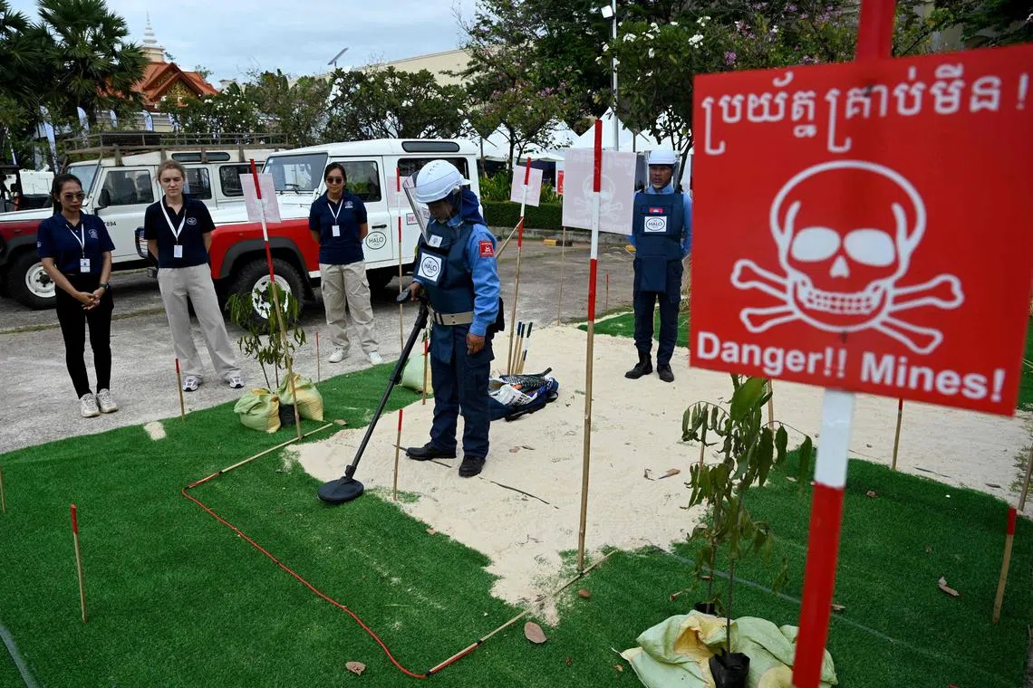 A deminer from the Hazardous Area Life-support Organisation (HALO trust) searches for landmines and unexploded ordnances as part of a demonstration at an exhibition during the Siem Reap-Angkor Summit on a Mine-Free World landmine conference in Siem Reap province on November 28, 2024.  (Photo by TANG CHHIN Sothy / AFP)