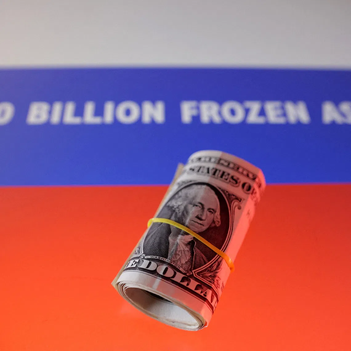 FILE PHOTO: U.S. dollar banknotes and Russian flag with words \"$300 billion frozen assets\" are seen in this illustration taken, February 21, 2025. REUTERS/Dado Ruvic/Illustration/File Photo
