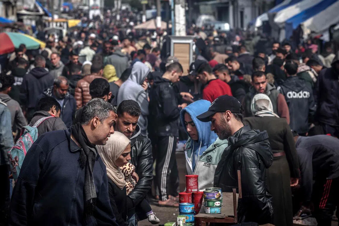 Palestinians selling canned food at a main street in Rafah, in the southern Gaza Strip, on Feb 19, 2024.