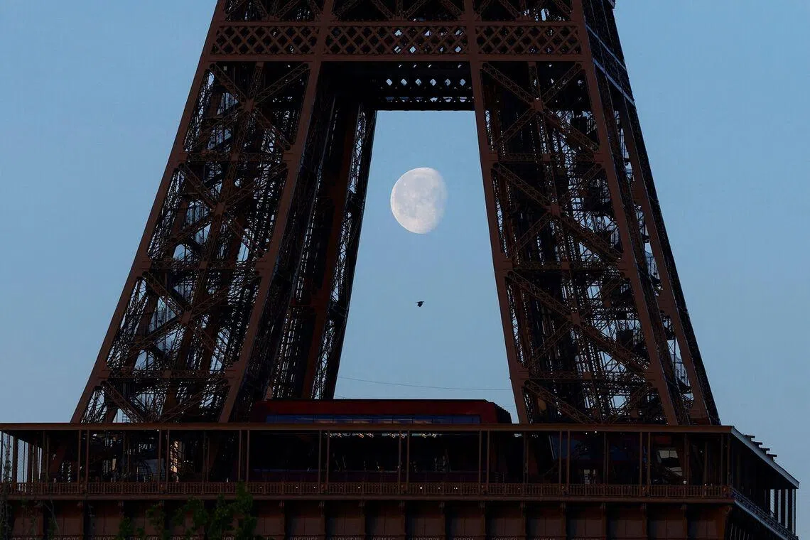 The moon behind the Eiffel Tower in Paris, on April 6, 2026.