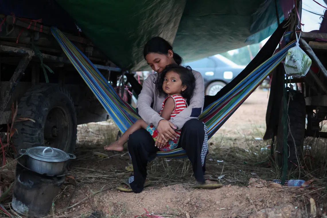 A woman carrying a child at a refugee camp after evacuation, amid deadly clashes between Thailand and Cambodia along a disputed border area, in Srei Snam, Siem Reap Province, Cambodia, on Dec 10, 2025. 