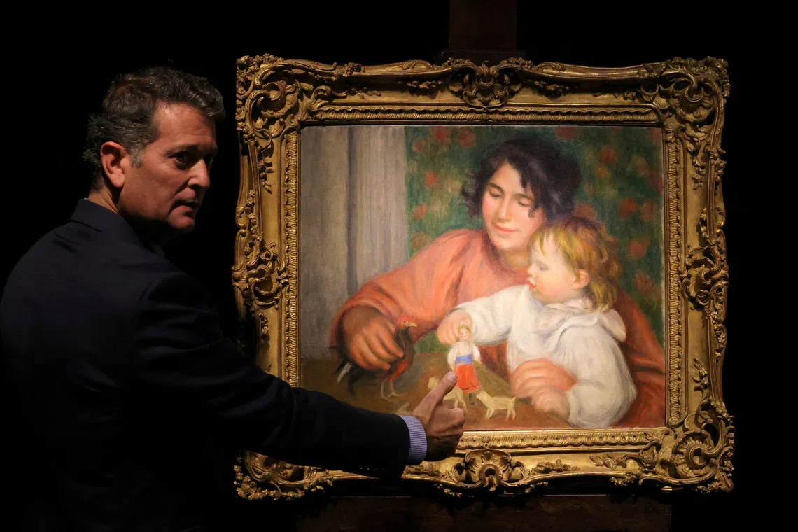FILE PHOTO: Art consultant Pascal Perrin stands next to the painting \"L'enfant et ses jouets - Gabrielle et le fils de l'artiste, Jean\" (Child with Toys - Gabrielle and the Artist's Son, Jean), before 1910, by artist Pierre-Auguste Renoir (1841-1919) on display before its auction at Drouot auction house in Paris, France, October 14, 2025. REUTERS/Yves Herman/File Photo