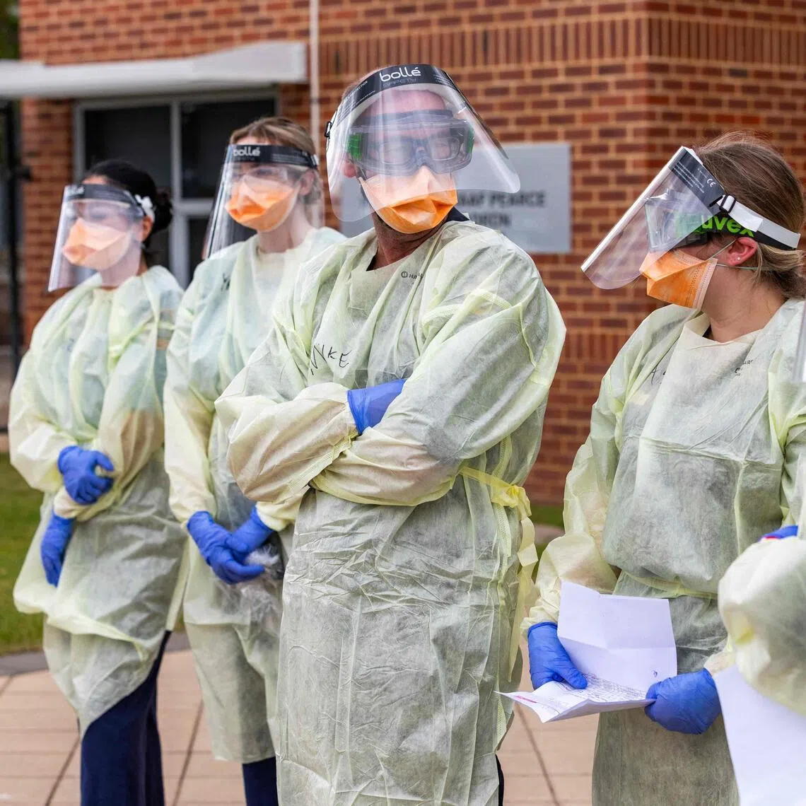 Officials from the Australian Medical Assistance Team and Australian Border Force standing near a plane that transported passengers caught up in the MV Hondius hantavirus outbreak on May 15.