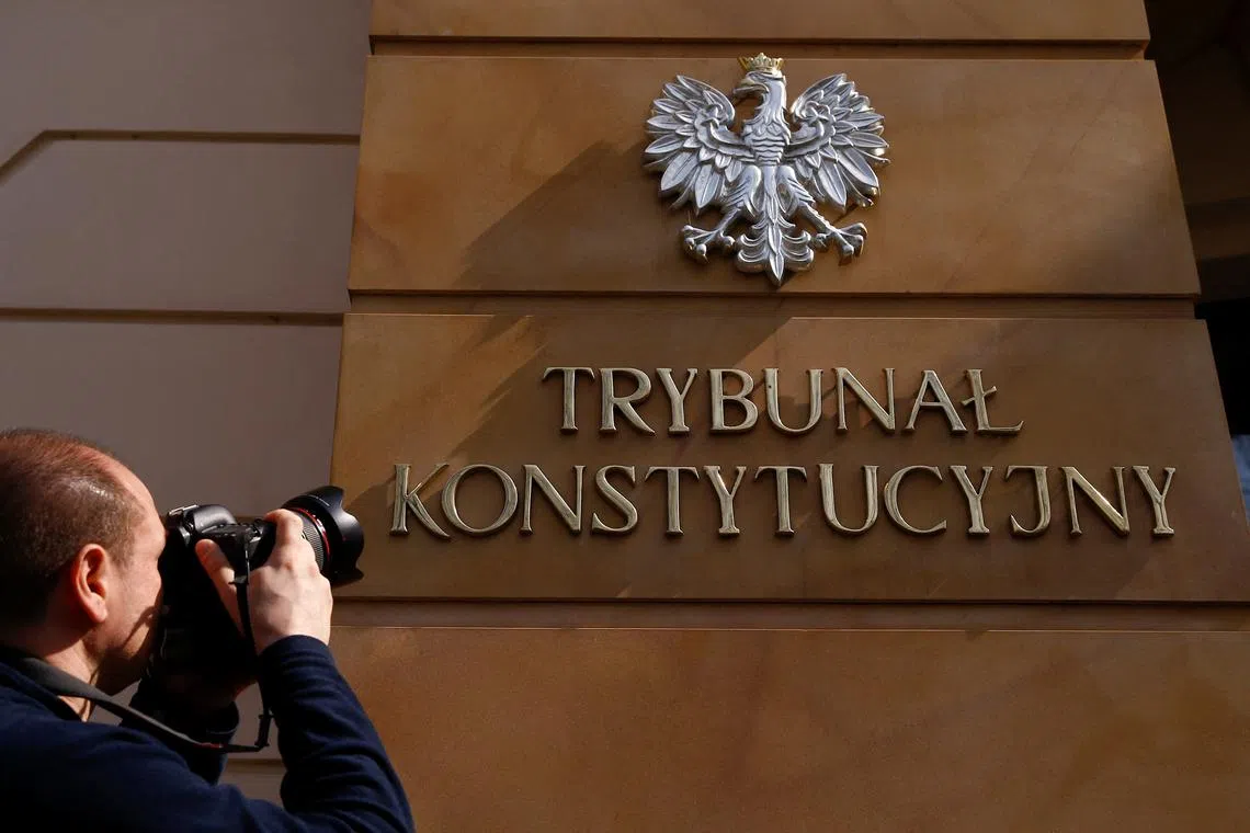 FILE PHOTO: A photographer takes a picture of the sign at the entrance to Poland's constitutional court in Warsaw, Poland April 5, 2016.  REUTERS/Kacper Pempel/File Photo