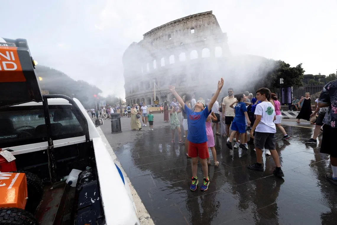 People cool off under a water mist near the Colosseum as Italy’s Civil Protection deploys measures to help residents and tourists cope with a heatwave, in Rome, Italy, June 26, 2026. REUTERS/Remo Casilli