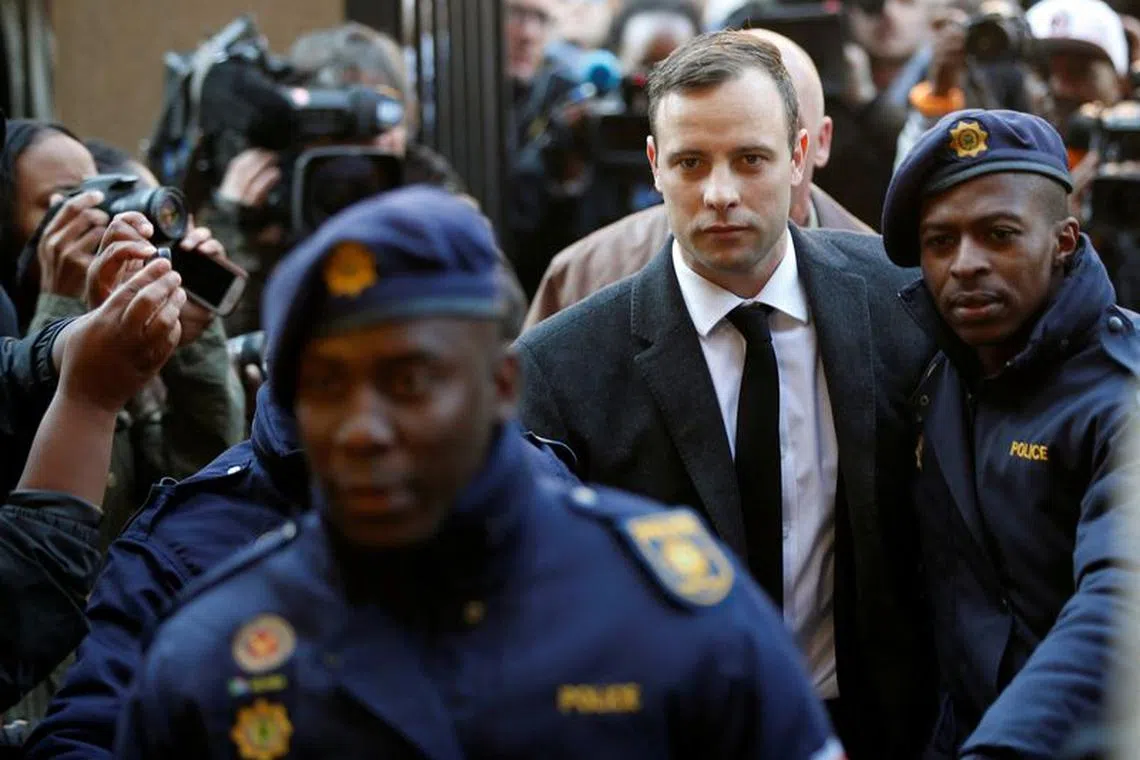 FILE PHOTO: Olympic and Paralympic track star Oscar Pistorius is escorted by police officers as he arrives for his sentencing for the 2013 murder of his girlfriend Reeva Steenkamp, at North Gauteng High Court in Pretoria, South Africa July 6, 2016. REUTERS/Siphiwe Sibeko/File Photo