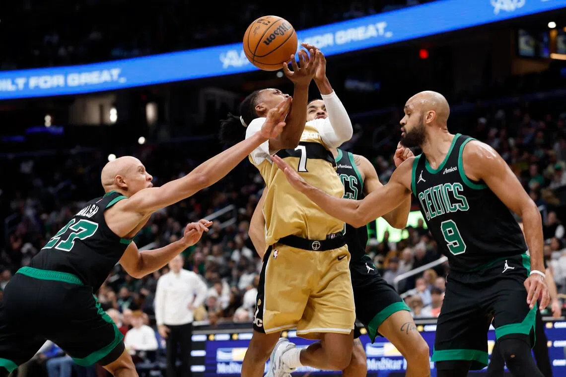 Washington Wizards guard Bub Carrington is fouled while driving to the basket by Boston Celtics guard Jordan Walsh.