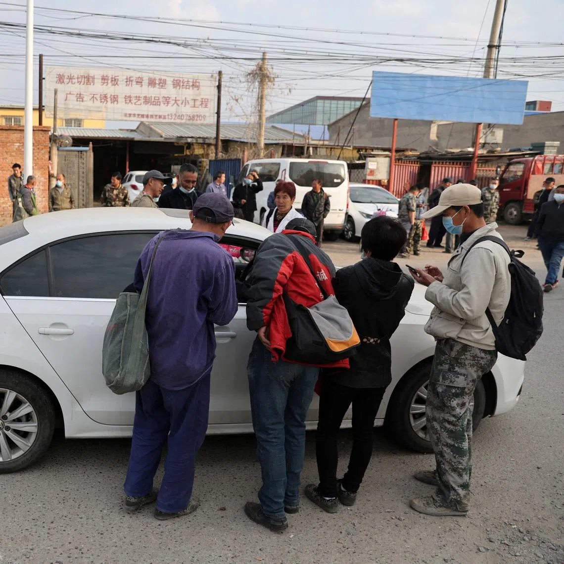 People asking for jobs on a street where labourers and migrant workers usually gather for odd jobs, near the border with Hebei province in Beijing in April 2022.
