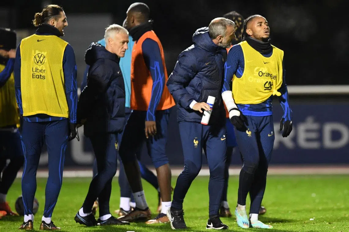 France forward Christopher Nkunku (right) limps out of a training session at the team's training camp in Clairefontaine-en-Yvelines, south of Paris, on Tuesday. 