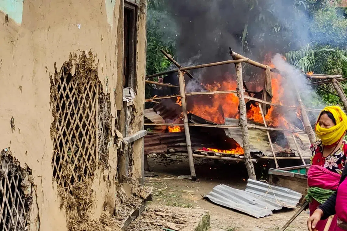 Women burn the house of one of the men accused of sexually assaulting two women in front of a mob in India’s Manipur state, on July 21, 2023.