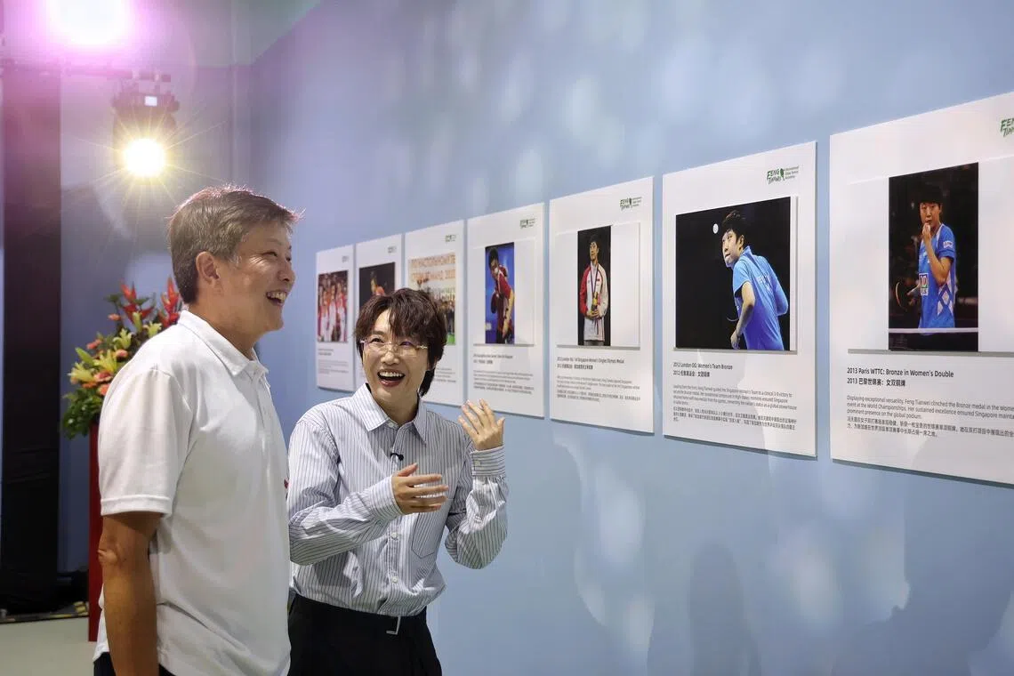 Singapore's Olympic medalist Feng Tianwei taking Jalan Kayu Member of Parliament Ng Chee Meng on a tour of a photo wall of her achievements during the grand opening of the Feng Tianwei International Table Tennis Academy at The Sports Arina @ Jalan Kayu.