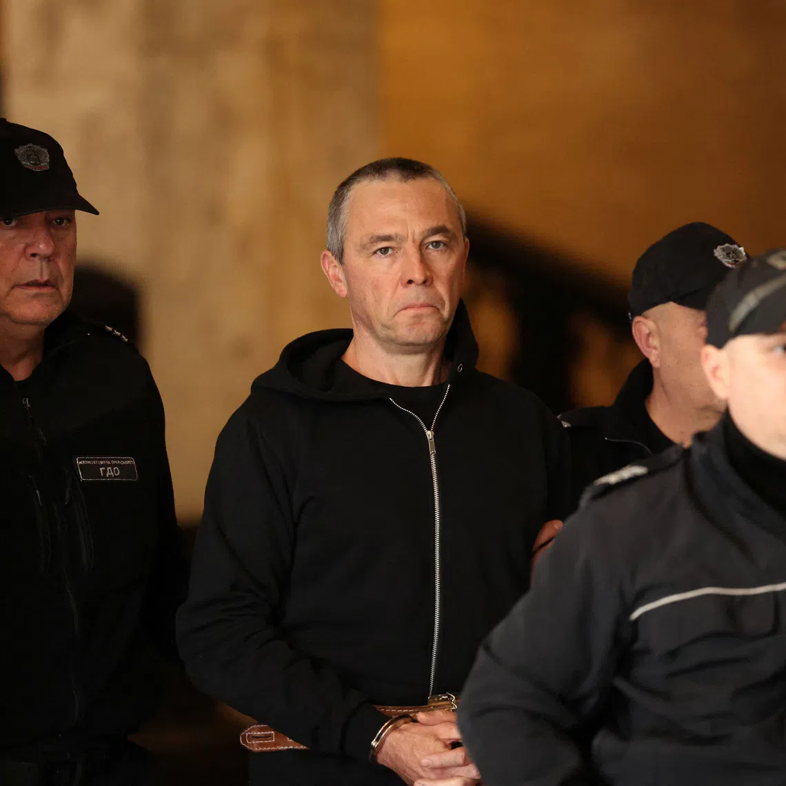Igor Grechushkin, a Russian businessman based in Cyprus, is escorted by police before the start of his trial on the possible extradition to Lebanon, in Sofia, Bulgaria, December 10, 2025. REUTERS/Stoyan Nenov