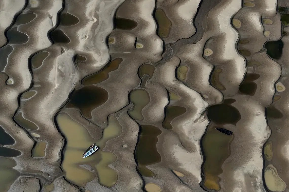 A drone view shows stranded boats over the sandbanks exposed due to drought at the Solimoes River, one of the largest tributaries of the Amazon River, during the most intense and widespread drought Brazil has experienced since records began in 1950, near Manacapuru, Amazonas state, Brazil September 30, 2024. REUTERS/Bruno Kelly