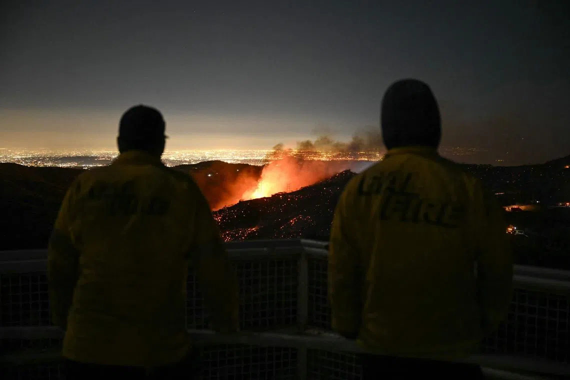 Firefighters monitor as the Palisades fire grows near the Mandeville Canyon neighborhood and Encino, California, on Jan 11, 2025. 