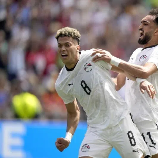  Emam Ashour (left) of Egypt celebrates with teammates Mostafa Ziko (centre) and Mohamed Salah after scoring the opening goal during the FIFA World Cup 2026 group stage match Belgium against Egypt, in Seattle, USA.