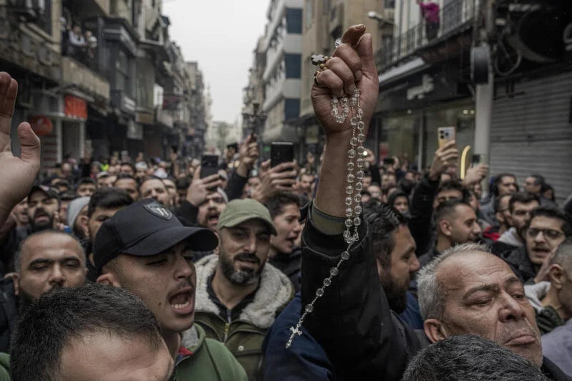 Demonstrators hold crosses and rosaries during a protest in the Bab Touma neighborhood of Damascus, on Tuesday, Dec. 24, 2024. Syrian Christians demonstrated against the burning of a Christmas tree overnight in the mostly Christian town of Suqaylabiyah by masked men in a video that began to circulate online on Monday. (Daniel Berehulak/The New York Times)