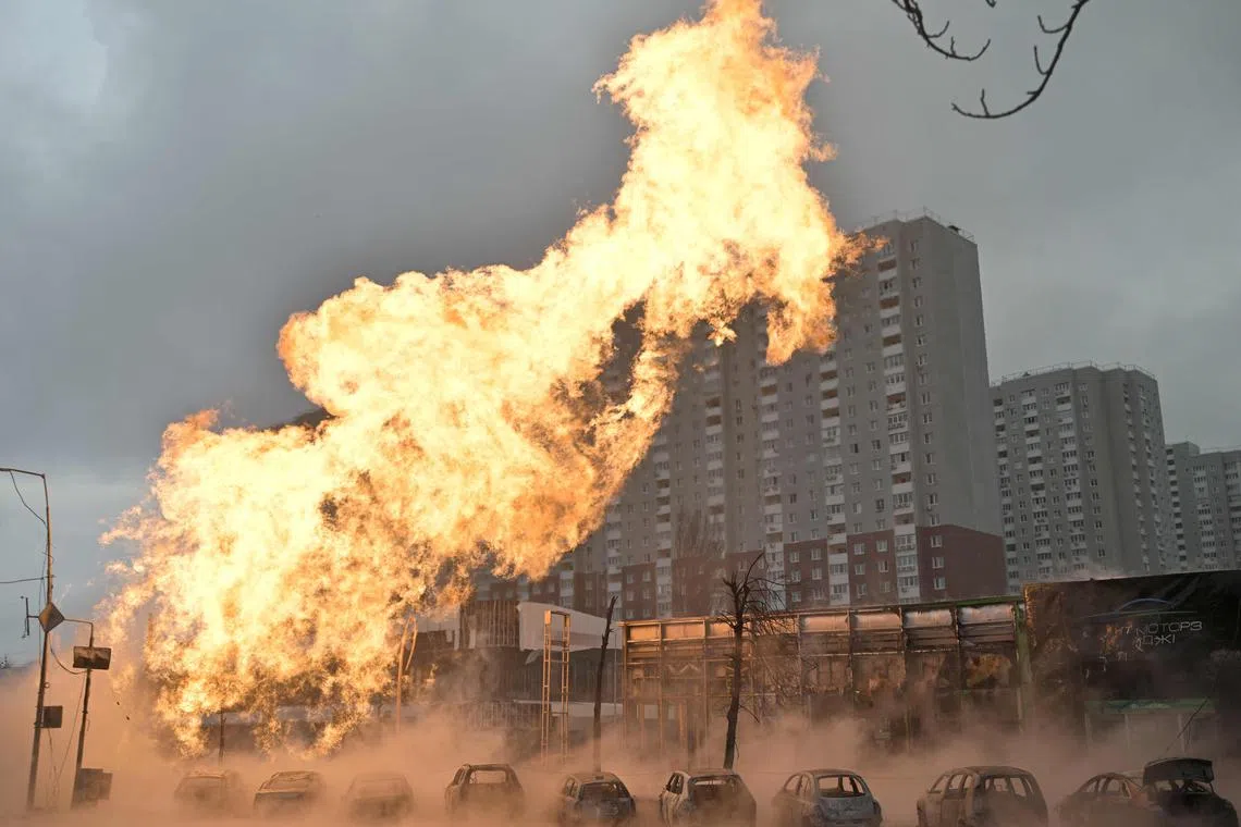 Fire and burnt-out cars are seen after a Russian missile strike in Kyiv.