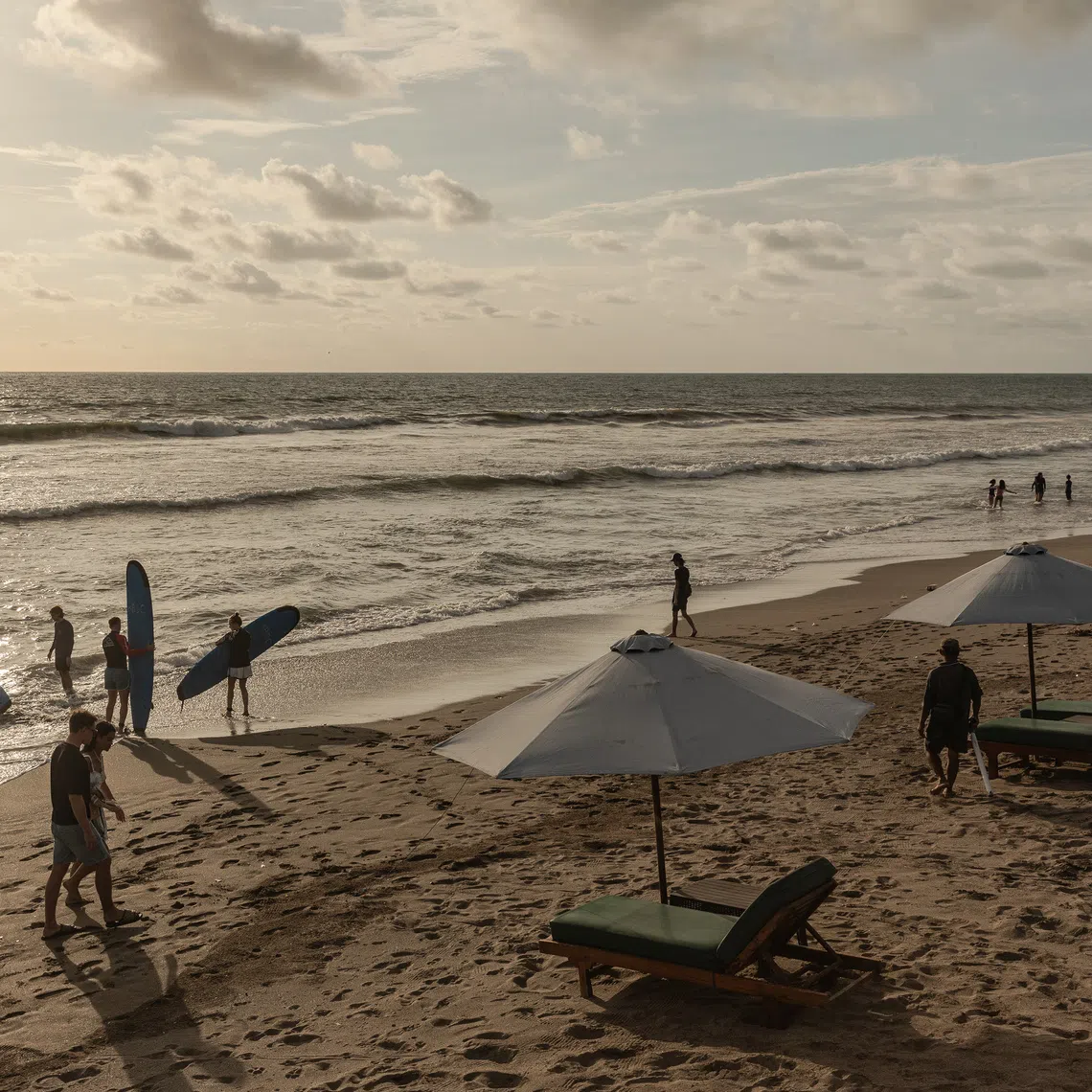 Surfers at Batu Belig beach in Bali on Nov 28. The development of mass tourism on the island was a deliberate strategy to resuscitate an economy shattered by the mass killings, historians say.