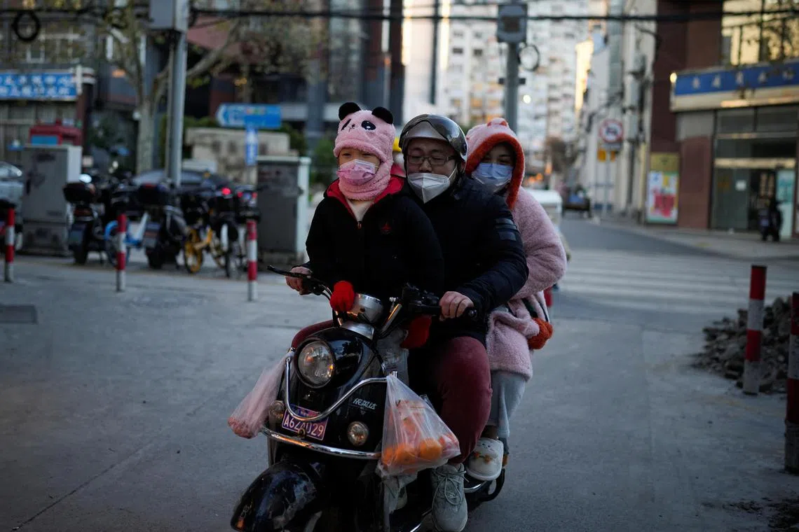 A family ride on a scooter through a street in Shanghai on Dec 23, 2022. 