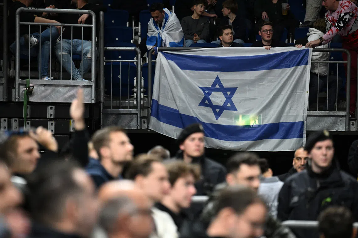 Basketball - EuroLeague - Alba Berlin v Maccabi Tel Aviv - Uber Arena, Berlin, Germany, November 28, 2024 Maccabi Tel Aviv fans with an Israel flag during the match REUTERS/Annegret Hilse