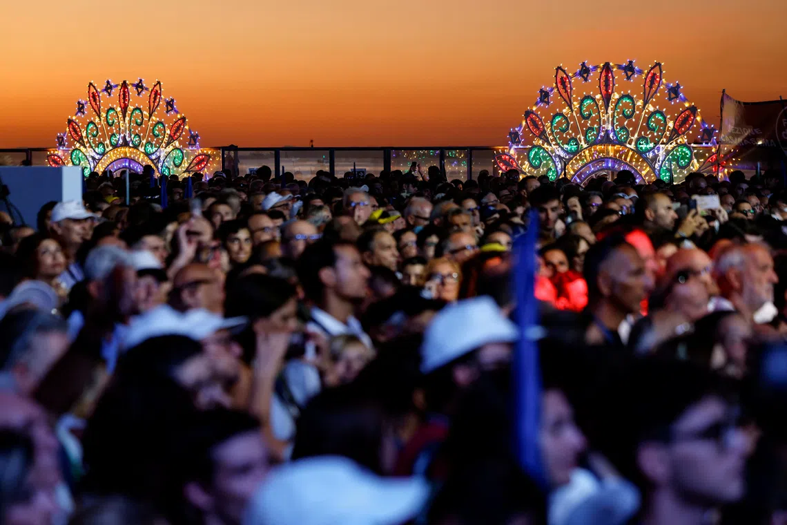People listen as Italian Prime Minister Giorgia Meloni delivers closing remarks at a rally on Sept 4.