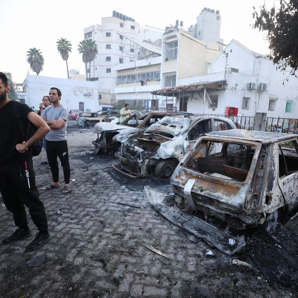 People inspect the area of Al-Ahli hospital where hundreds of Palestinians were killed in a blast that Israeli and Palestinian officials blamed on each other, and where Palestinians who fled their homes were sheltering amid the ongoing conflict with Israel, in Gaza City, October 18, 2023. REUTERS/Mohammed Al-Masri