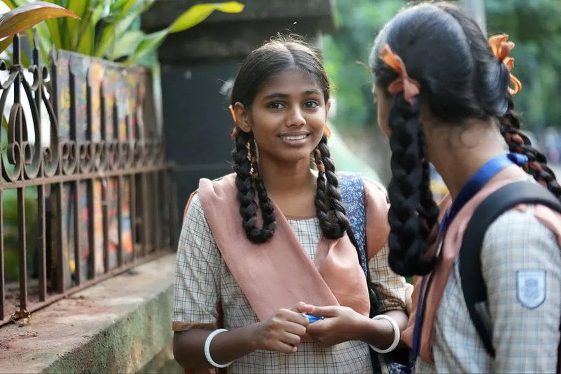Maleesha Kharwa, 15, a model and Instagram influencer, talks to a classmate as they arrive to attend their classes outside a school in Mumbai, India, September 11, 2023. REUTERS/Hemanshi Kamani