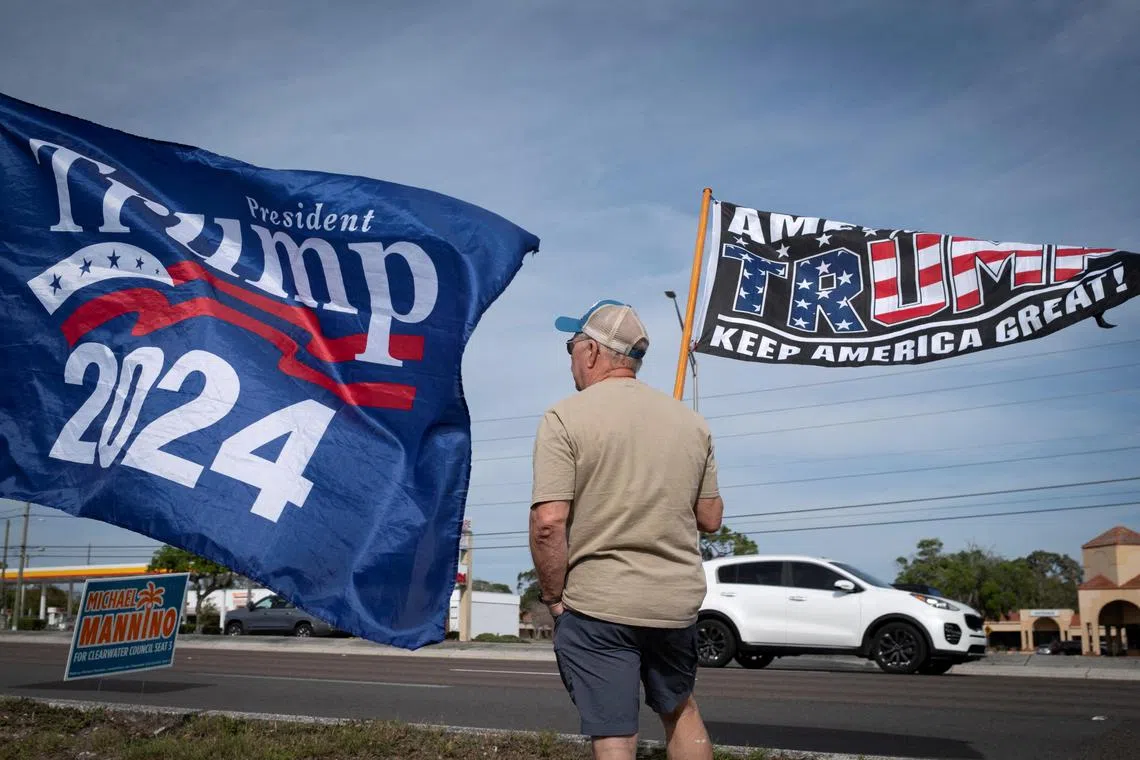 A supporter of Republican presidential candidate and former US President Donald Trump waves a flag during a gathering in Palm Harbor, Florida, on March 10.
