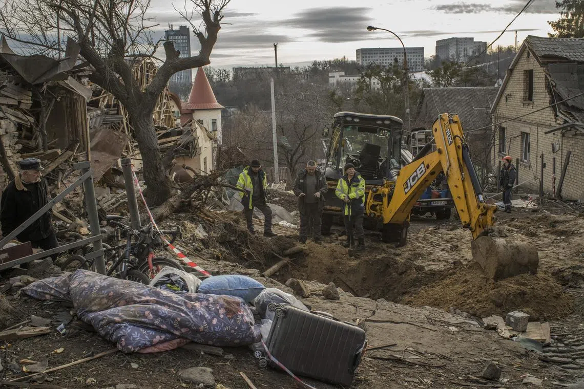 Workers at the site of a missile strike in Kyiv, Ukraine, on Jan. 1, 2023. Ten months into the war, Ukraine has turned the tide in ground combat, but its cities are still facing relentless waves of missiles and exploding drones. (Laura Boushnak/The New York Times)
