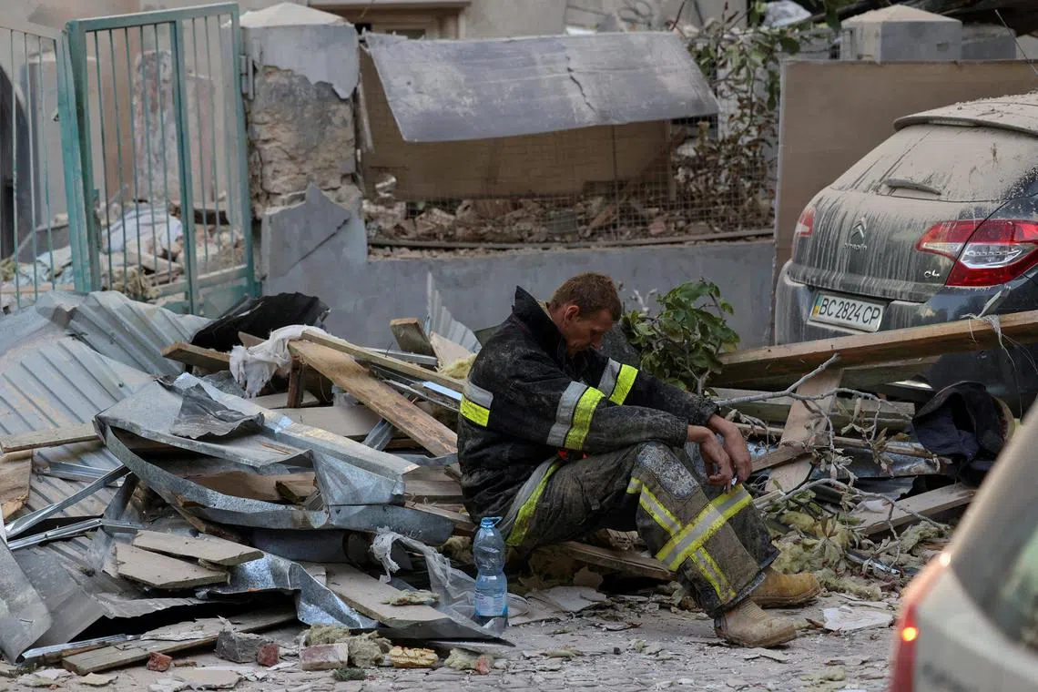 A rescuer resting at the site of a Russian drone and missile strike on residential buildings in Lviv, Ukraine, on Sept 4.