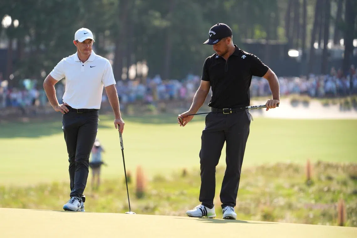FILE PHOTO: Jun 14, 2024; Pinehurst, North Carolina, USA; Rory McIlroy (left) and Xander Schauffele on the 13th hole during the second round of the U.S. Open golf tournament at Pinehurst No. 2. Mandatory Credit: John David Mercer-USA TODAY Sports