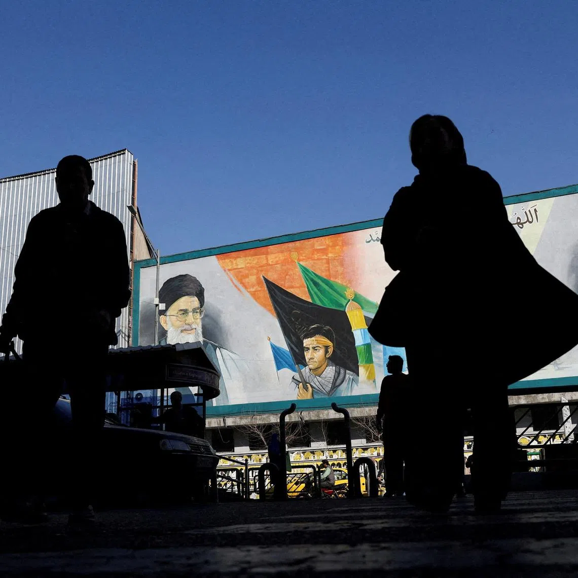 FILE PHOTO: People walk near a mural featuring images of Iran's Supreme Leader Ayatollah Ali Khamenei and leader of Iran's 1979 Islamic Revolution Ayatollah Ruhollah Khomeini, on a street in Tehran, Iran, February 17, 2026. Majid Asgaripour/WANA (West Asia News Agency) via REUTERS