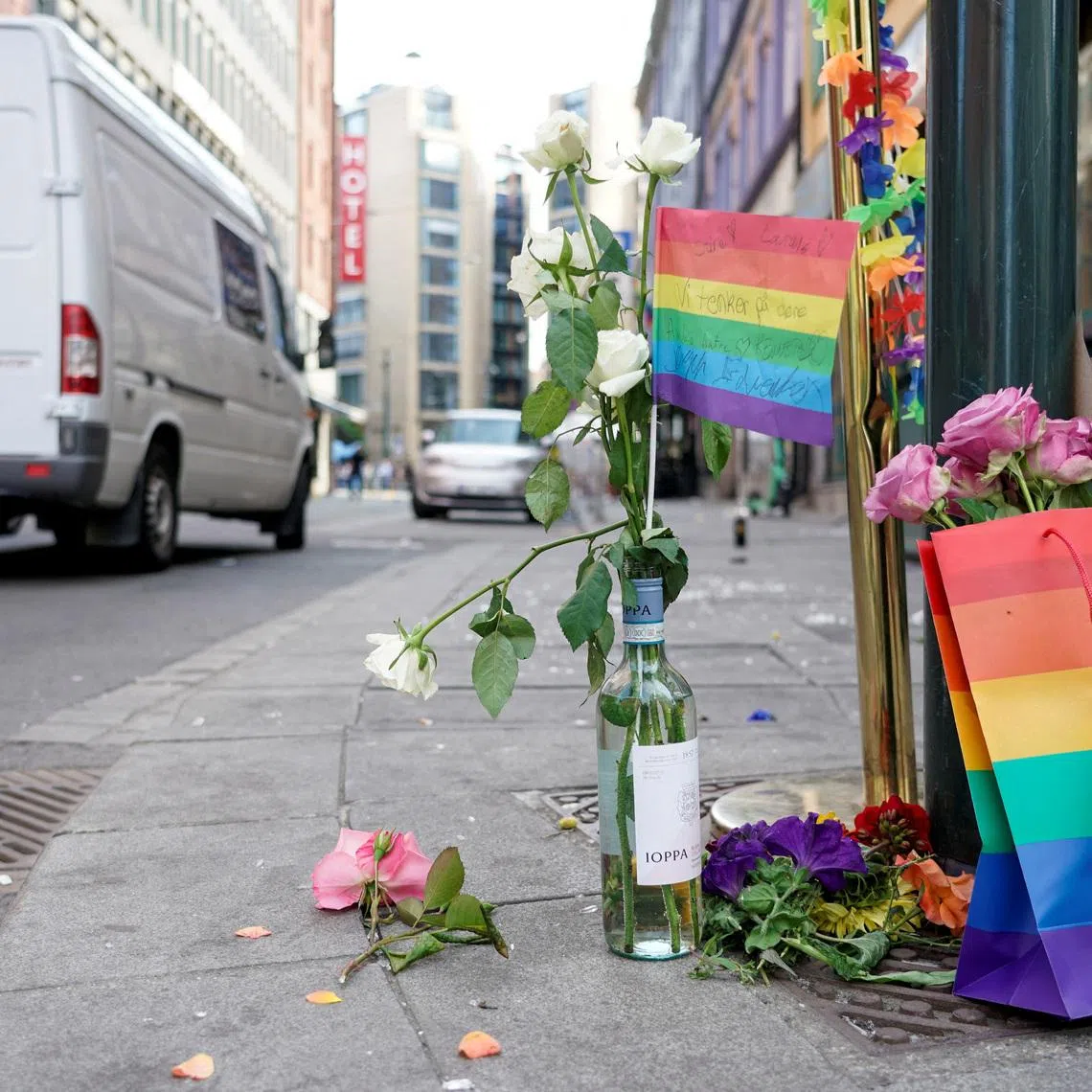 FILE PHOTO: A rainbow flag and flowers are placed as a tribute on a sidewalk following a shooting at a nightclub in central Oslo, Norway June 25, 2022. Terje Pedersen/NTB/via REUTERS/File Photo