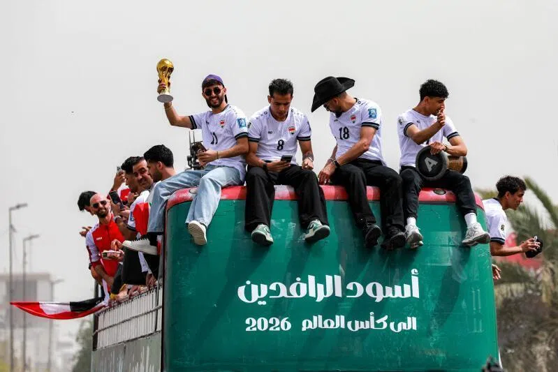 Members of Iraq's men's national football team sitting atop a double-decker bus as they are paraded with fans in Baghdad, Iraq on April 4 to celebrate the country's qualification to the 2026 FIFA World Cup.