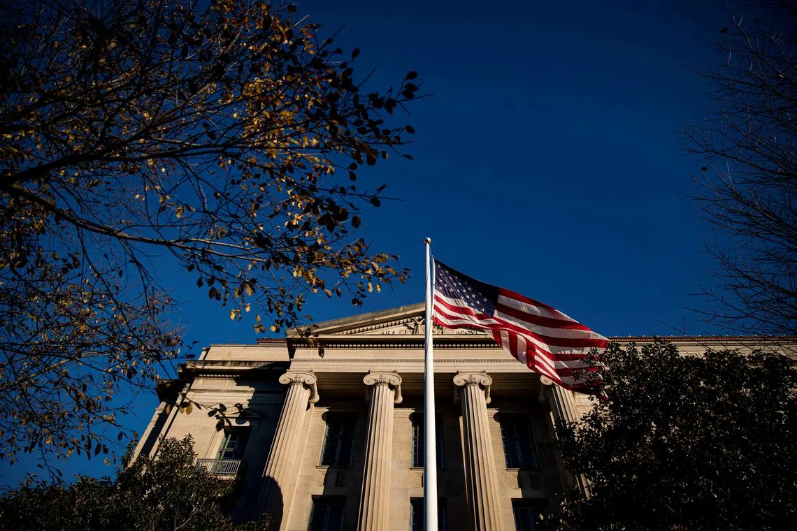 FILE PHOTO: An American flag waves outside the U.S. Department of Justice Building in Washington, U.S., December 15, 2020. REUTERS/Al Drago/File Photo