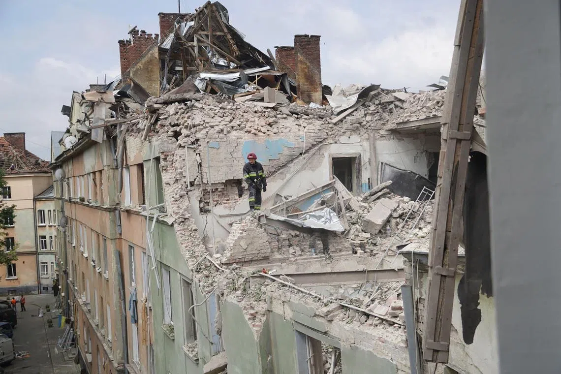 A rescuer works in an apartment building partially destroyed by the missile strike.