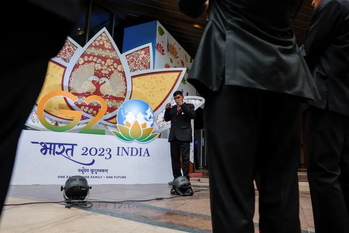 Indian security pose for selfies in front of a G20 sign outside the International Media Center during the G20 Summit in New Delhi, India, September 9, 2023. REUTERS/Evelyn Hockstein