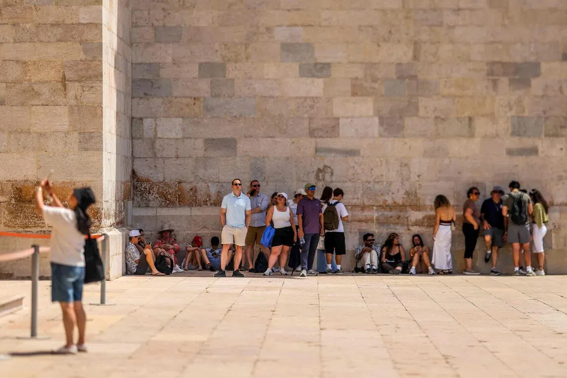 Tourists resting in the shade outside Jeronimos Monastery in Belem, during a heatwave in Lisbon on May 27.