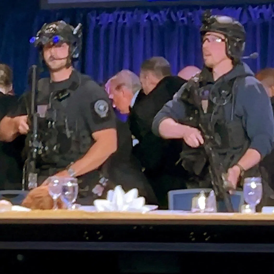 US President Donald Trump being escorted out after a man opened fire with a shotgun on security personnel outside the room, during the White House Correspondents' Association dinner in Washington DC.