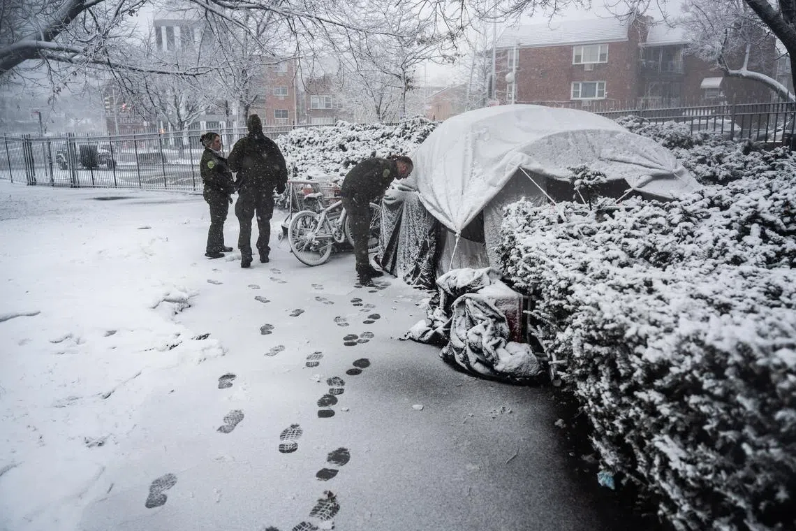 Parks Department officers check on men who had been living in a tent in a park in Queens as a winter storm intensified on Feb 22.