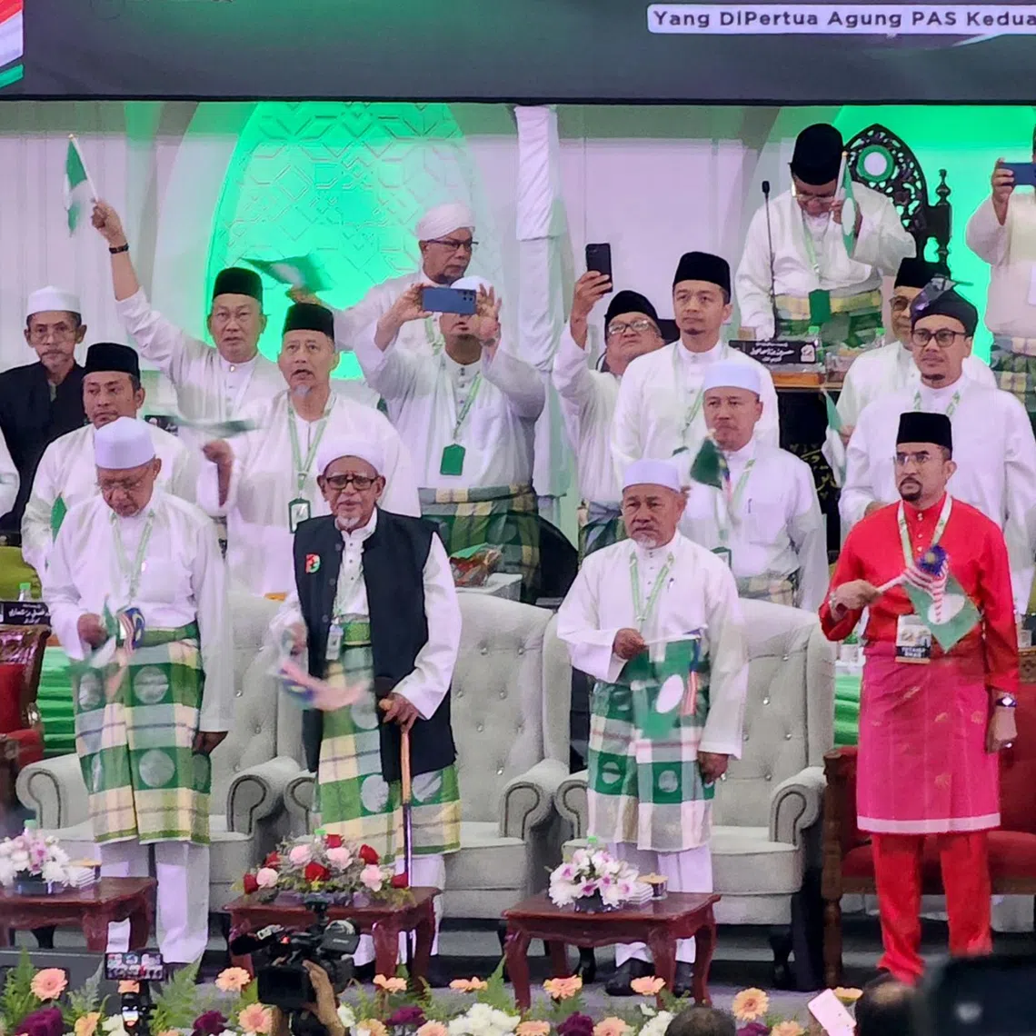 UMNO secretary-general Asyraf Wajdi Dusuki (in red) makes an appearance at PAS’ annual muktamar in Kelantan, on Sept 4,  in a show of solidarity as both parties gear up for the next general election.