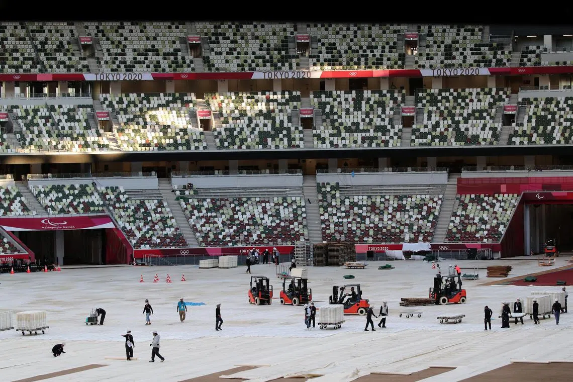 Workers at the National Stadium, the main venue of the Tokyo 2020 Olympic and Paralympic Games, in August 2021.