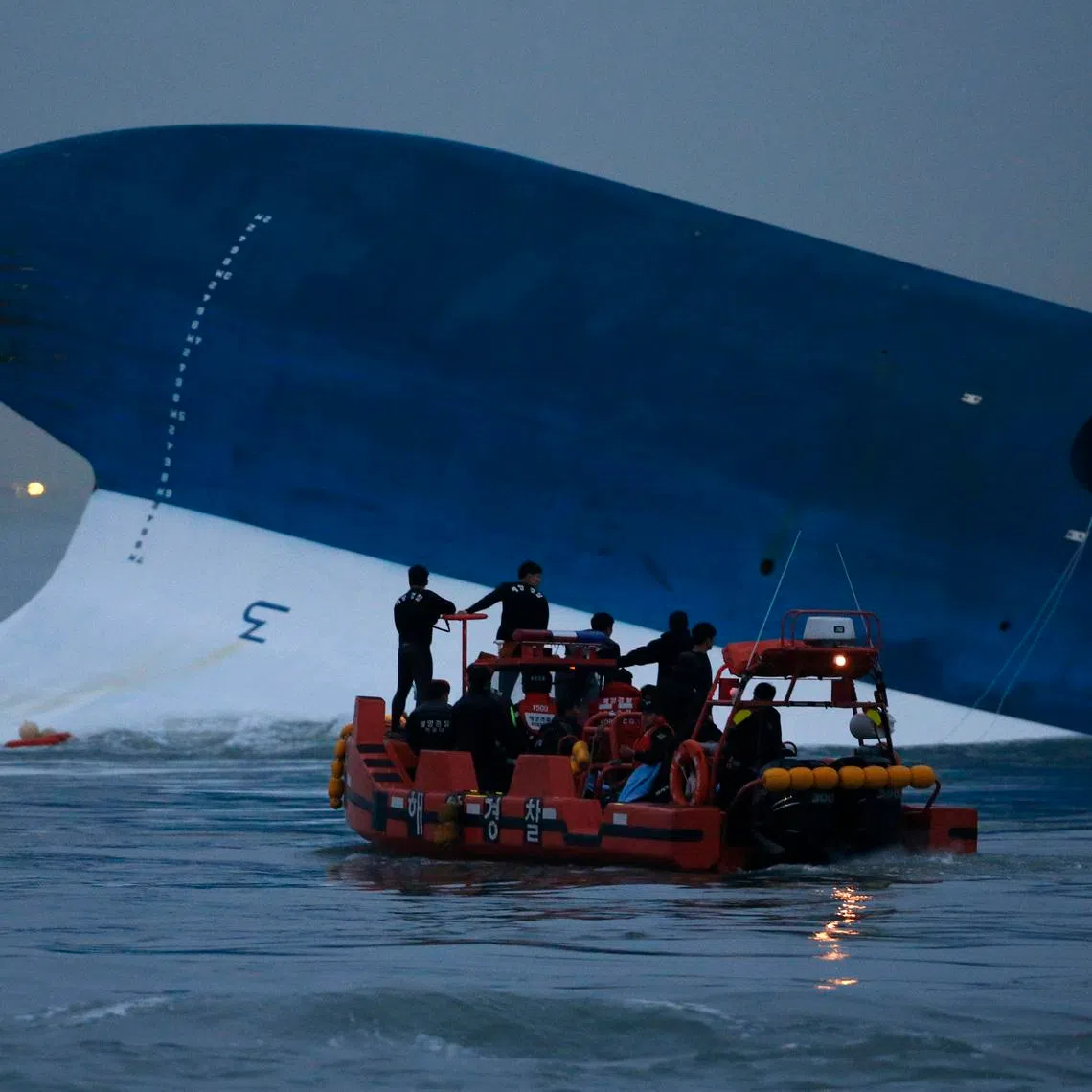 Maritime police search for missing passengers in front of the South Korean ferry Sewol which sank at the sea off Jindo, on April 16, 2014.