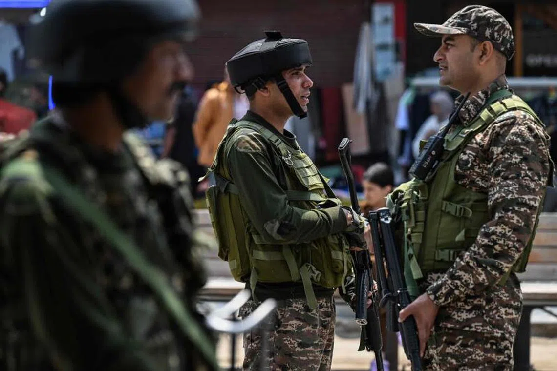 Indian paramilitary soldiers keep guard along a street in Srinagar on May 4, 2025. Tensions between the nuclear-armed arch-rivals have soared since India accused Pakistan of backing a shooting that killed 26 civilians on the Indian side of the disputed territory on April 22. (Photo by Sajjad HUSSAIN / AFP)