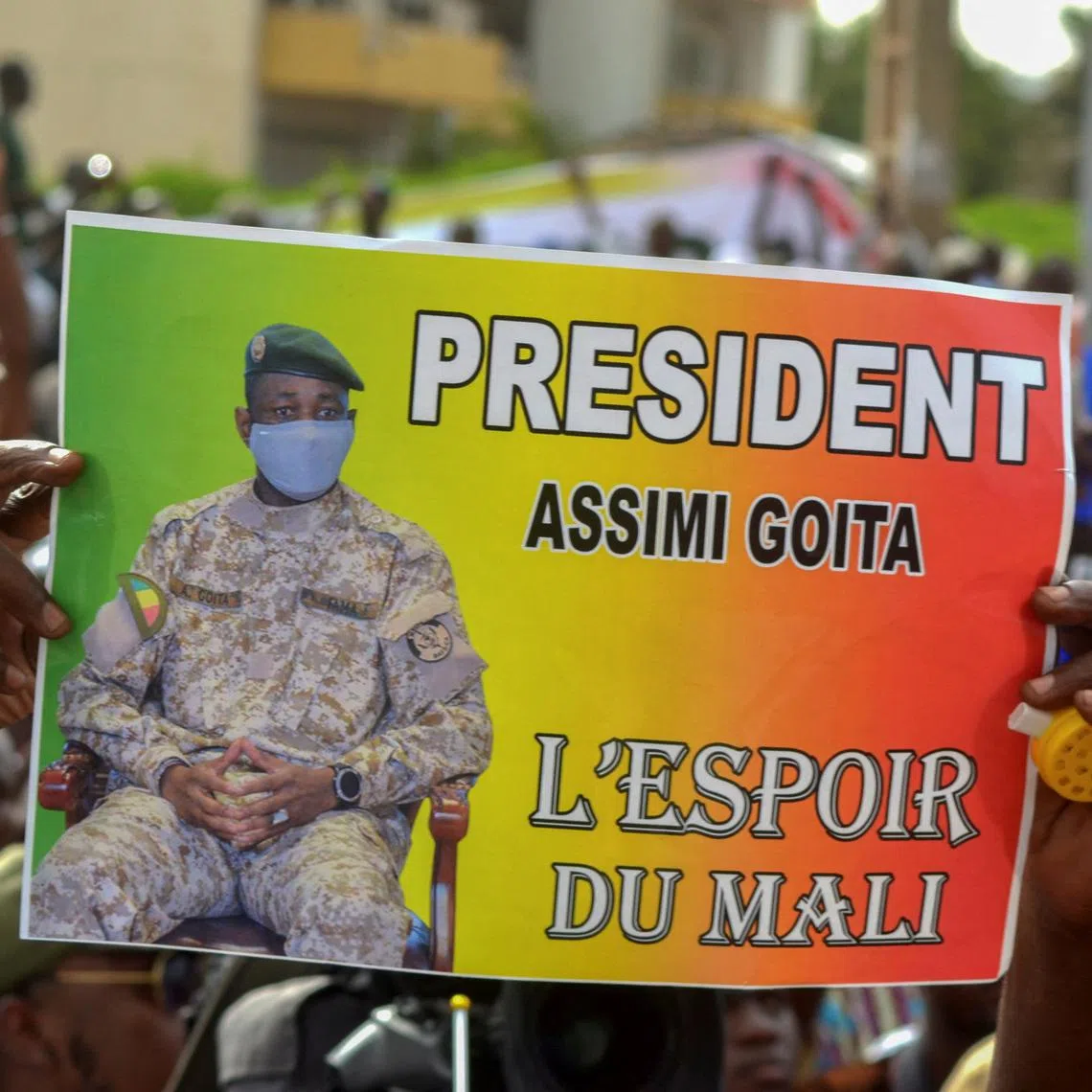 FILE PHOTO: A supporter of Mali's M5-RFP opposition coalition, holds a poster of the colonel Assimi Goita during a rally to mark a year since the start of protest marches that contributed to the ouster of former President Ibrahim Boubakar Keita at the Independence Square in Bamako, Mali June 4, 2021. The poster reads \"President Assimi Goita - the hope of Mali\". REUTERS/Amadou Keita/File Photo