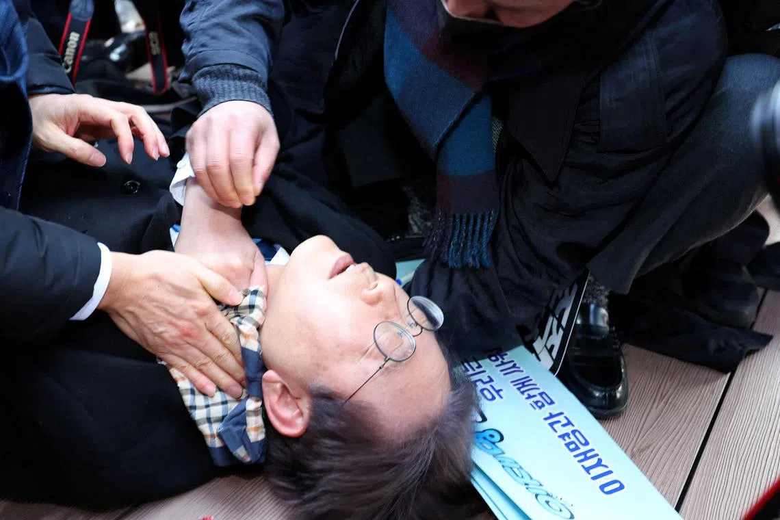 South Korea's opposition party leader Lee Jae-myung falls after being attacked by an unidentified man during his visit to Busan, South Korea.