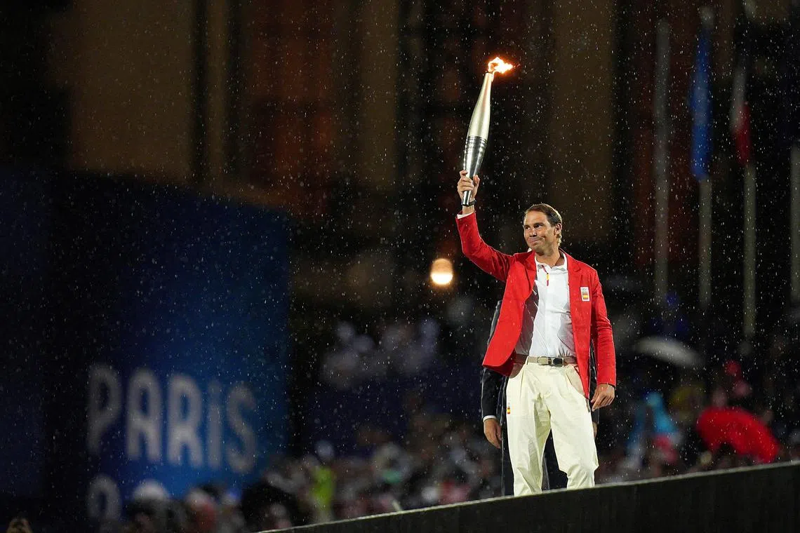 FILE PHOTO: Paris 2024 Olympics - Opening Ceremony - Paris, France - July 26, 2024. Rafael Nadal of Spain holds the Olympic torch during the opening ceremony of the Paris 2024 Olympic Games.     Xu Chang/Pool via REUTERS/File Photo