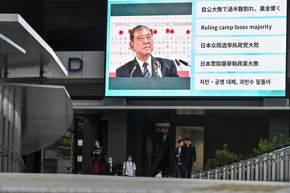 A large television screen shows Japan's Prime Minister Shigeru Ishiba on Oct 28, a day after his Liberal Democratic Party lost its Lower House majority in a general election.